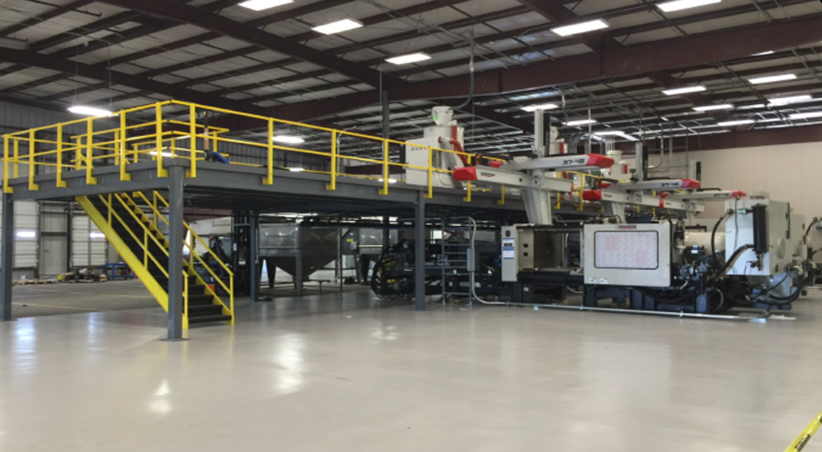 Warehouse interior with large machine and platform for the workers.